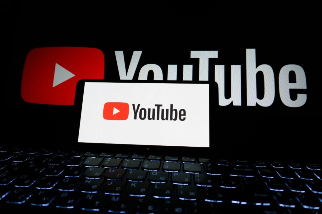 Best Side Hustles to Make Money in 2025 Close-up of YouTube logo displayed on a laptop screen in a dark environment.